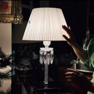 آباژور رو میزی باکارات طلایی بر روی میز کنار تخت در یک اتاق خواب مدرن